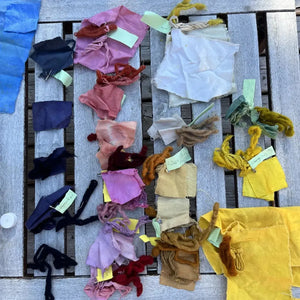 Various colored fabric-dyed cloths are showcased on the table.